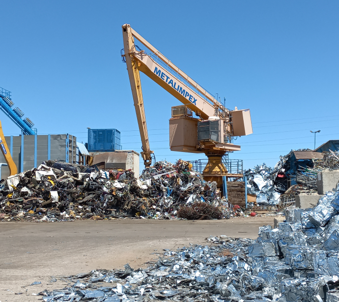 Grue jaune Metalimpex qui est entrain de séparer plusieurs métaux différents.