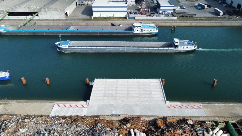 Bateau qui passe devant un quai de chargement de marchandises